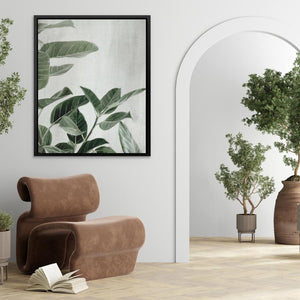 a living room with a chair, potted plant and a framed picture