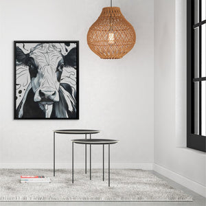 a living room with a cow painting on the wall