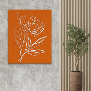 a vase with a plant in it next to an orange wall