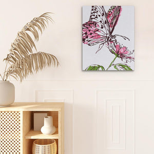 a white vase with a pink flower and a butterfly on it