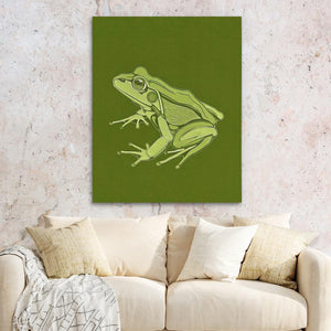 a green frog sitting on top of a white couch