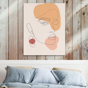 a painting of a woman's face on a wall above a bed