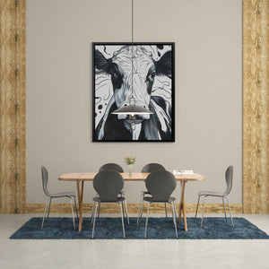 a picture of a cow hangs above a dining room table