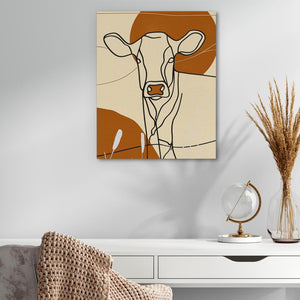 a painting of a cow on a wall above a desk