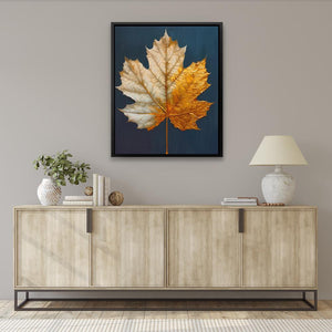 a framed picture of a maple leaf on a wall