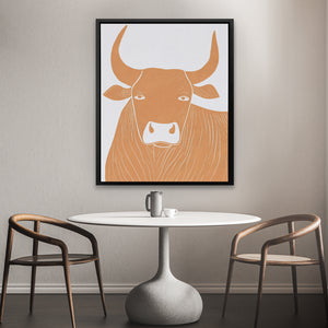 a picture of a cow on a wall above a table