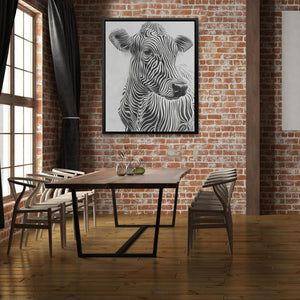 a picture of a zebra is hanging on a brick wall