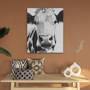 a painting of a cow on a wall above a table