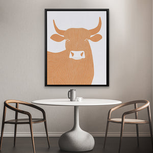 a picture of a cow on a wall above a table