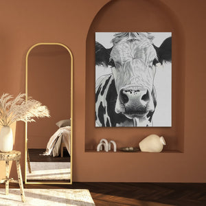 a painting of a cow is hanging on a wall