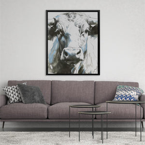 a living room with a couch and a cow painting on the wall