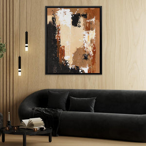 a living room with a black couch and a painting on the wall