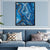 a living room with a blue couch and a painting on the wall