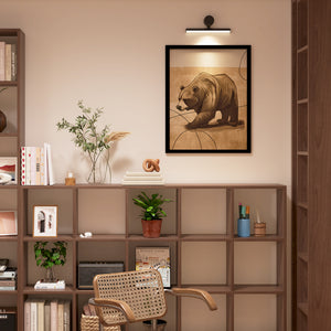 a picture of a bear on a wall above a book shelf