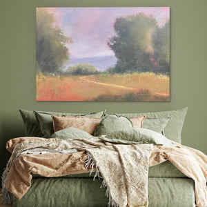 a bed with a green comforter and a painting on the wall