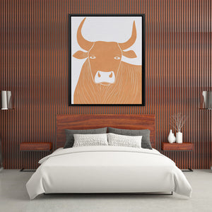 a picture of a bull on a wall above a bed