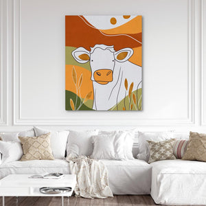 a living room with a white couch and a cow painting on the wall