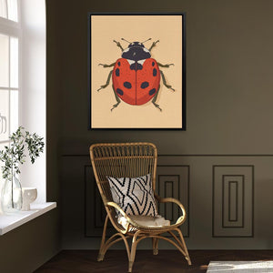 a picture of a ladybug on a wall above a chair