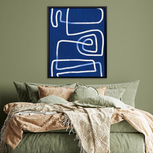 a bed with a blue painting on the wall above it