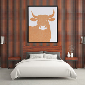 a picture of a cow on a wall above a bed