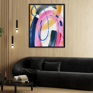 a living room with a black couch and a painting on the wall