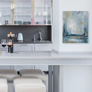 a kitchen with a white counter top and a painting on the wall