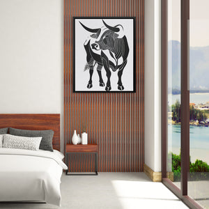 a picture of a cow hanging on a wall above a bed