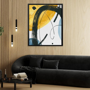 a living room with a black couch and a painting on the wall