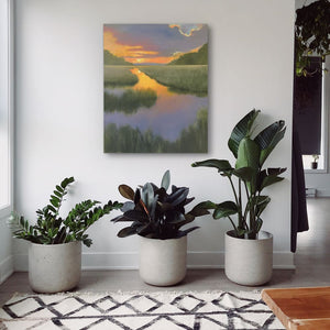 three potted plants sit in front of a painting