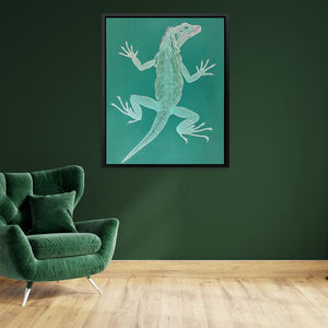 a living room with a green chair and a painting of a lizard on the wall