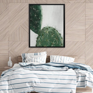 a picture of a cactus on a wall above a bed