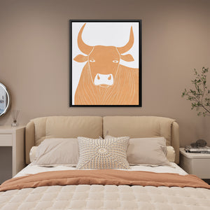 a picture of a bull on a wall above a bed