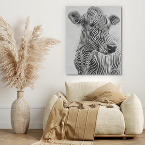 a picture of a cow on a wall above a couch